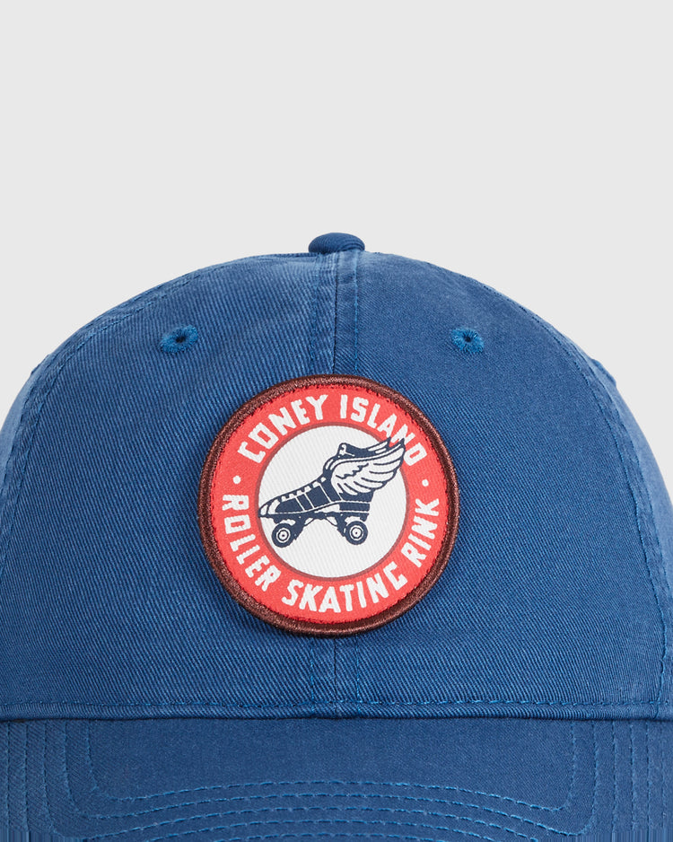 The Ebbets Field Coney Island Roller Skating Rink Washed Cotton Ballcap features blue cotton fabric and a circular patch with a roller skate and “Coney Island Roller Skating Rink” in white and red—a tribute to classic Brooklyn style.
