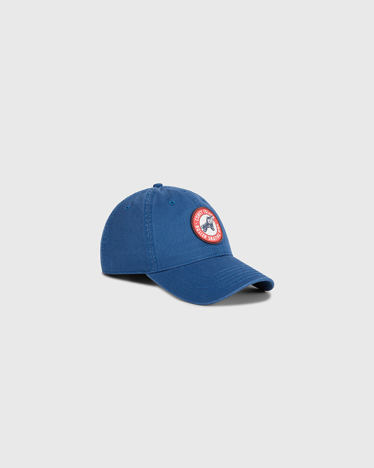 The Ebbets Field Coney Island Roller Skating Rink Washed Cotton Ballcap in blue features a curved brim and a round red, white, and blue patch logo on the front, shown against a plain light gray backdrop for timeless Brooklyn style.