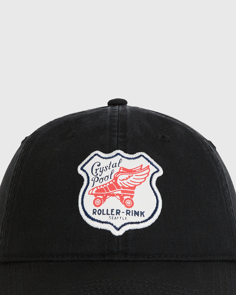 The Seattle Crystal Pool Roller Rink Washed Cotton Ballcap by Ebbets Field features a patch with a red winged roller skate and 