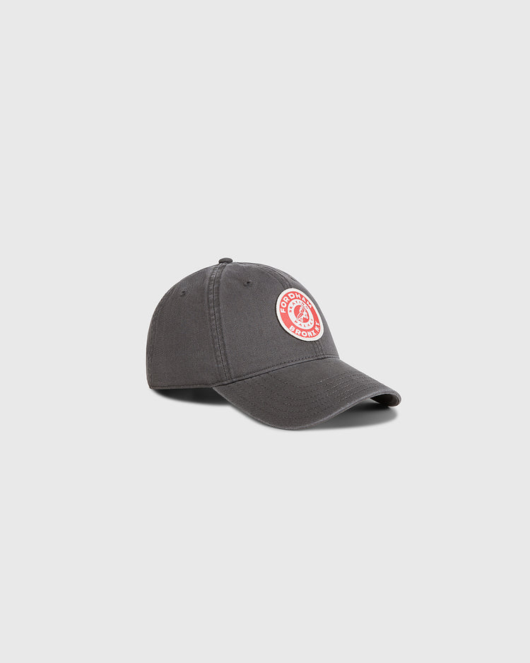 The Ebbets Field Fordham Bronx Roller Rink Washed Cotton Ballcap is a dark gray baseball cap with a curved brim and vintage-inspired red and white patch, shown on a plain light gray background.