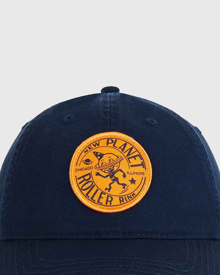 The Chicago New Planet Roller Rink Washed Cotton Ballcap by Ebbets Field is a navy vintage hat with a round yellow patch showing a ringed planet and the words 