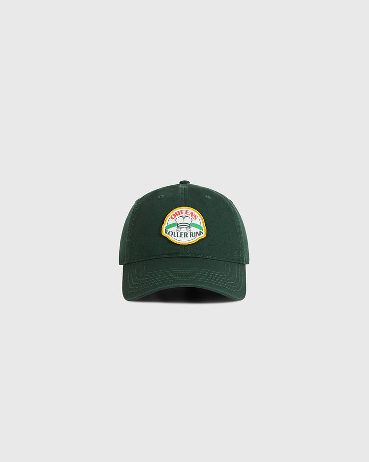 The Queens Roller Rink Washed Cotton Ballcap by Ebbets Field is a dark green vintage hat with a colorful 