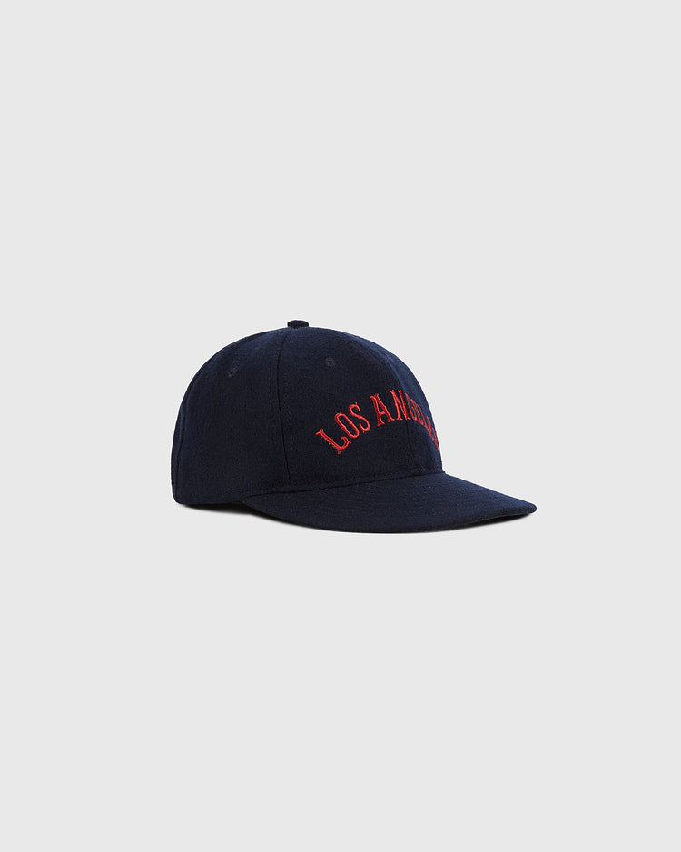 The Ebbets Field Los Angeles City Series Wool Ballcap is navy blue with “LOS ANGELES” embroidered in red on the front, shown against a plain light gray background.