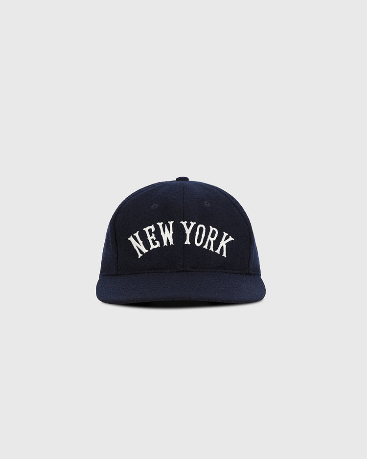The Ebbets Field New York City Series Wool Ballcap features NEW YORK in white uppercase embroidery on navy wool broadcloth, shown against a plain light gray background.