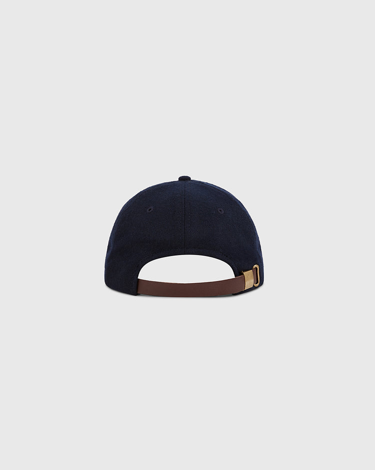 The Ebbets Field New York City Series Wool Ballcap in navy is shown from the back, featuring a brown adjustable strap with gold buckle and an open section above it, set against a plain light gray background.
