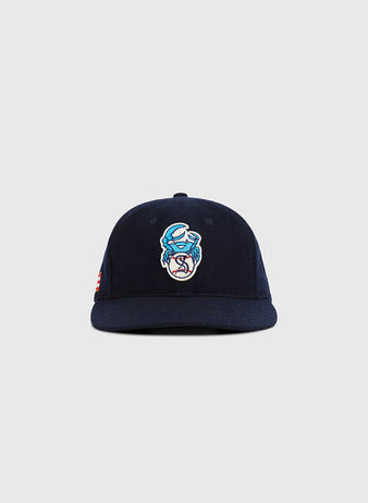 The Santurce Cangrejeros Crab Wool Ballcap by Ebbets Field is a navy blue cap with an embroidered cartoon crab logo in light blue, white, and red, displayed against a plain light gray background.