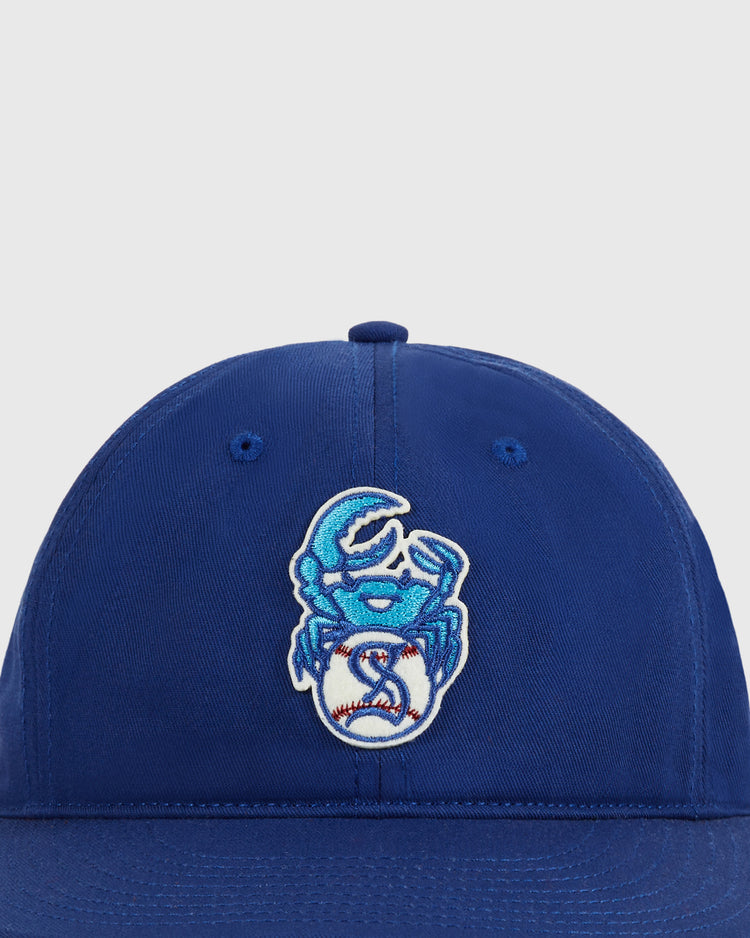 The Ebbets Field Santurce Cangrejeros Crab Cotton Twill Ballcap is a blue hat with an embroidered blue crab holding a white baseball, honoring Puerto Rican baseball and the legendary Cangrejeros team.