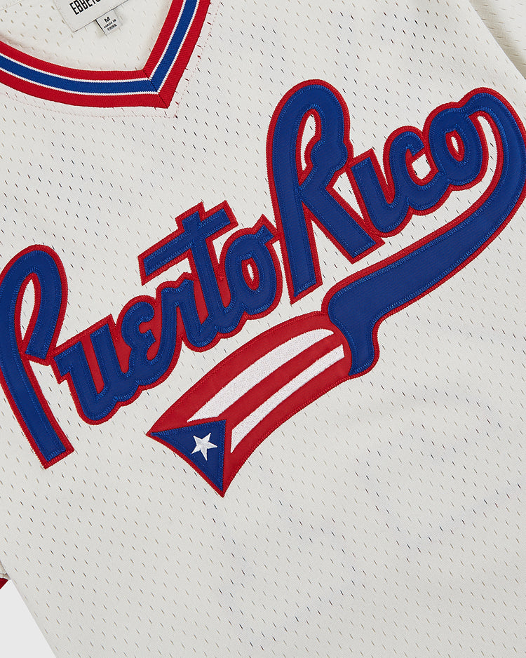 The Ebbets Field Puerto Rico 1972 National Team Mesh V-Neck Jersey features white mesh with blue and red script, plus a red, white, and blue flag design—ideal for fans of Puerto Rican baseball history.