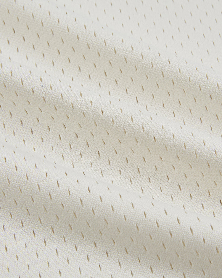 Close-up of the off-white, perforated mesh fabric from the Ebbets Field Puerto Rico 1972 National Team Mesh V-Neck Jersey, showing its lightweight and breathable texture.