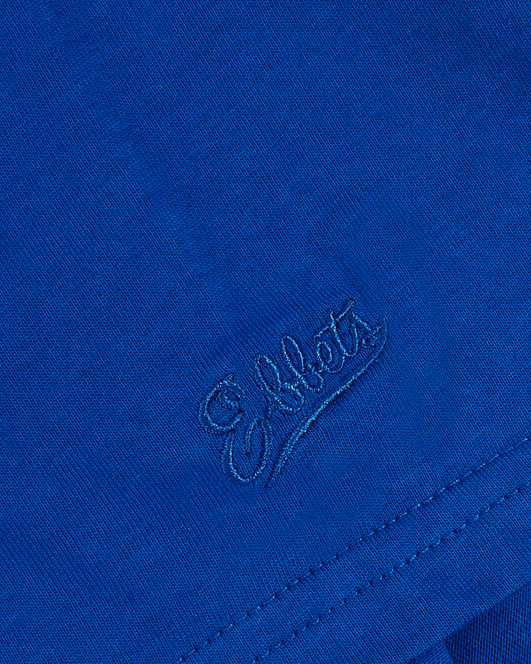 Close-up of blue fabric on the Ebbets Field Puerto Rico 1958 National Team Short Sleeve Tee, featuring “Eiffel” embroidered in cursive near the hem with visible texture and stitching details.