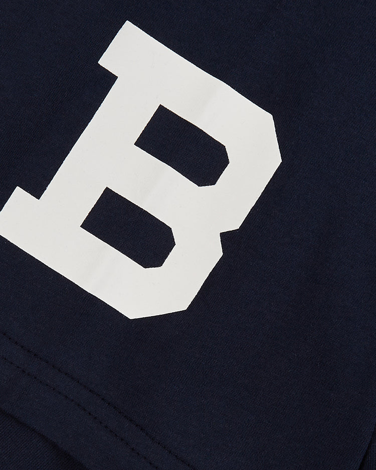 A close-up of the Brooklyn Bushwicks Short Sleeve Graphic Tee by Ebbets Field, featuring navy blue fabric with a large white block letter B, inspired by vintage independent league baseball style.