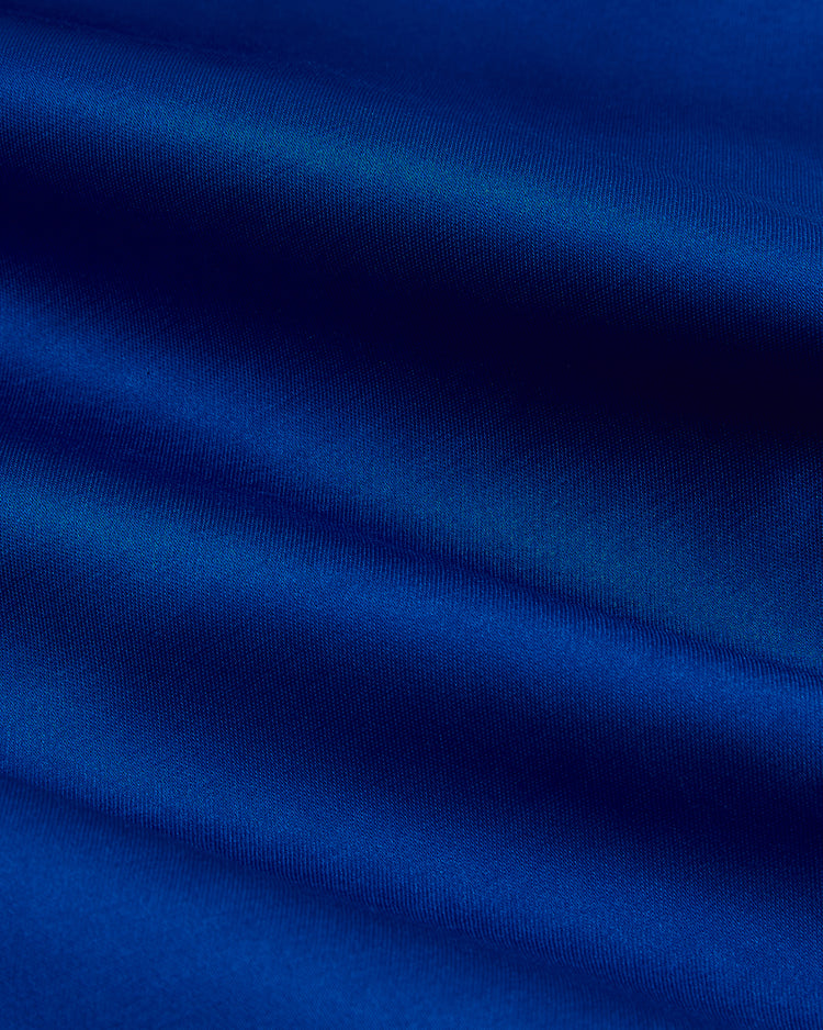 Close-up of smooth, shiny blue satin—just like the rich color on an EFF Los Angeles Dodgers 1962 Satin Windbreaker Jacket—reminiscent of classic on-field styles under Dodger Stadium lights.