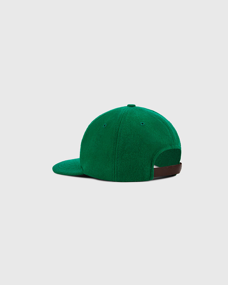 The Ebbets Field New York Cosmos Wool Ballcap, shown from the back with a curved brim and adjustable brown strap, features green textured wool inspired by Pelé’s era and stands out against a light gray background.