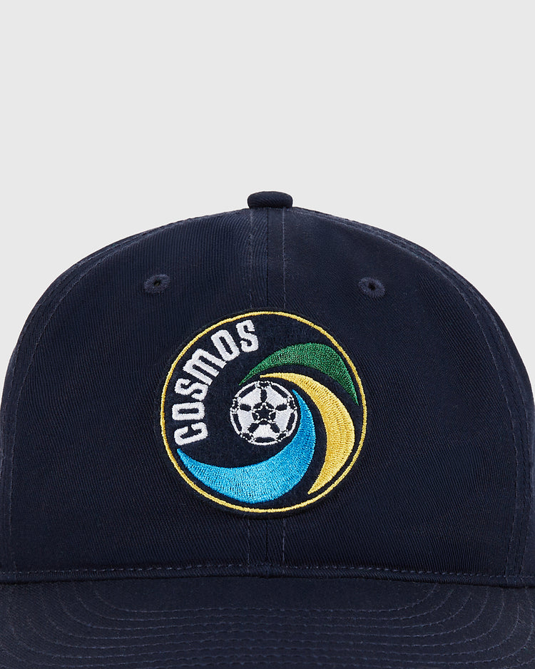 The Ebbets Field New York Cosmos Cotton Twill Ballcap features an embroidered Cosmos logo with a soccer ball and swirling blue, green, and yellow accents—COSMOS in white—a nod to Pelé's legendary team.