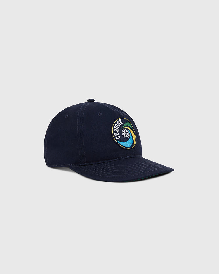 The Ebbets Field New York Cosmos Cotton Twill Ballcap is a navy hat with an embroidered circular COSMOS star logo on the front, inspired by the team, shown on a plain light gray background.