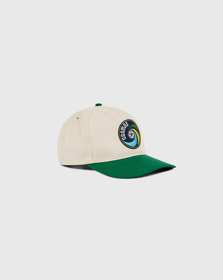 The Ebbets Field New York Cosmos A-Frame Cotton Twill Ballcap features a beige crown, green brim, and a front patch with a blue globe and 