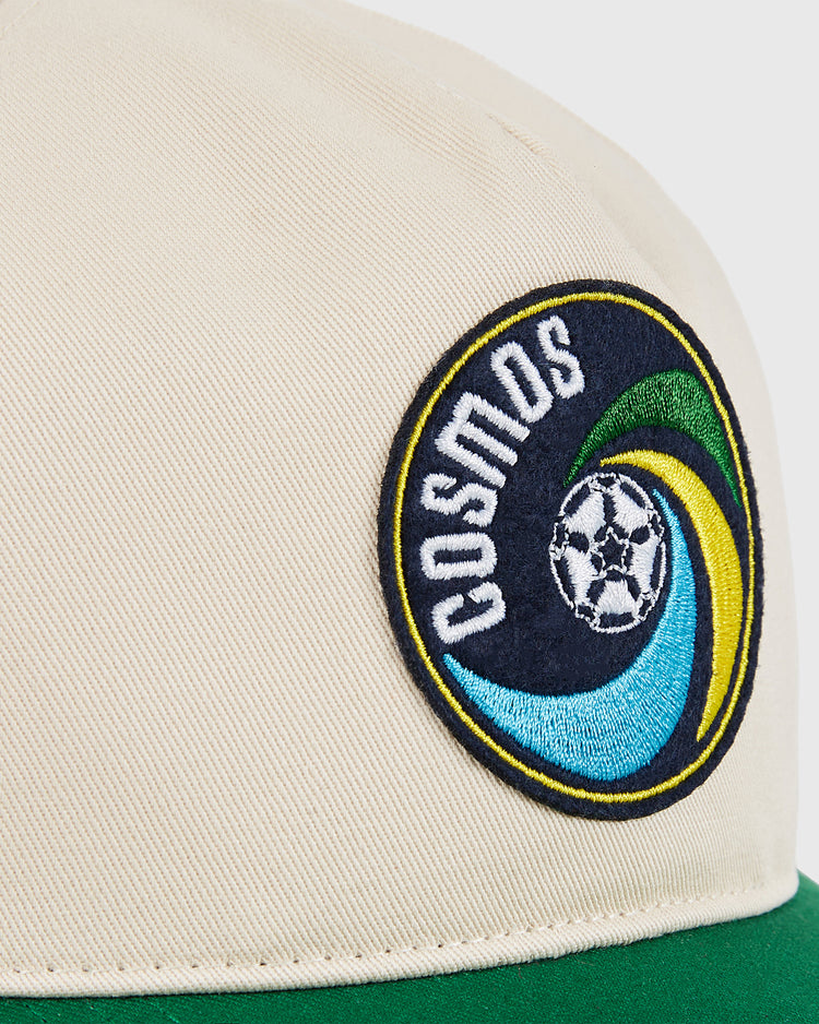 Close-up of the Ebbets Field New York Cosmos A-Frame Cotton Twill Ballcap in beige with a retro circular embroidered patch featuring 