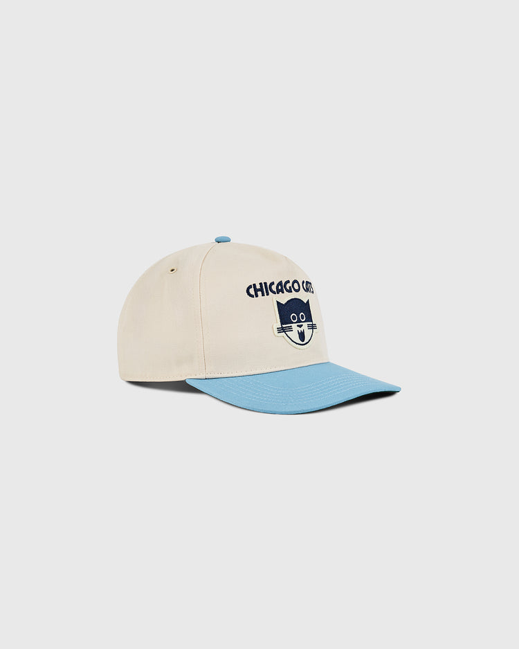 The Ebbets Field Chicago Cats A-Frame Cotton Twill Ballcap is beige with a light blue brim, a navy cartoon cat face, and “CHICAGO CAT” embroidered on the front. Shown as a retro snapback on a plain white background.
