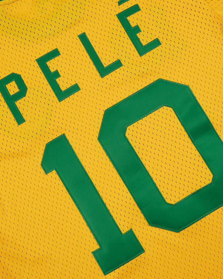 Yellow New York Cosmos Soccer Mesh Jersey by Ebbets Field featuring “PELÉ” and number 10 in green, inspired by the legendary Brazilian footballer’s iconic American soccer era.