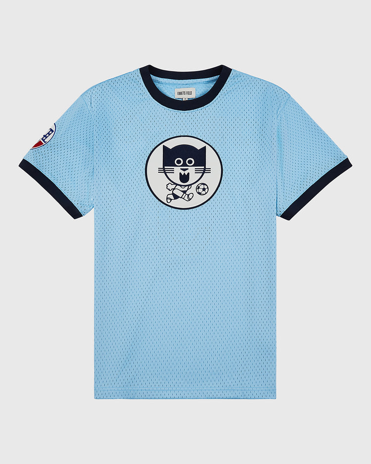 The Ebbets Field Chicago Cats Mesh Soccer Jersey is light blue with navy collar and sleeve trim, features a circle chest print of a cartoon cat playing soccer, inspired by classic Chicago Cats style, plus a small left sleeve patch.