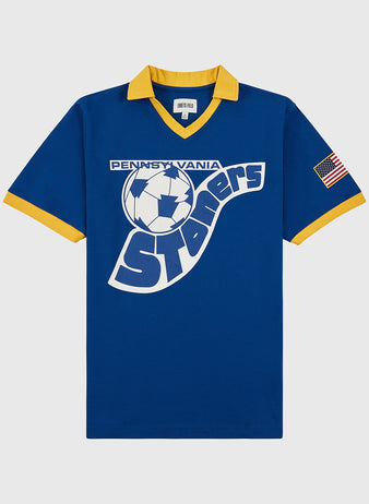 The Ebbets Field Pennsylvania Stoners Vintage Collar Soccer Jersey features blue cotton fabric, yellow collar and cuffs, a large vintage-style soccer ball and team name screen print on the front, plus an American flag patch on the left sleeve.