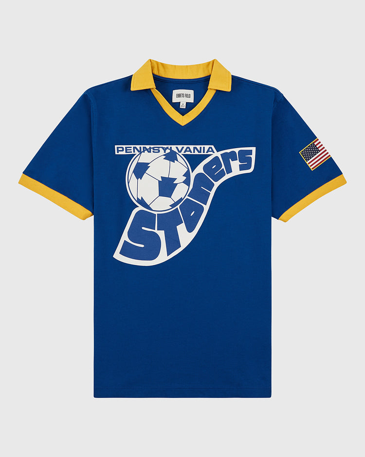 The Ebbets Field Pennsylvania Stoners Vintage Collar Soccer Jersey features blue cotton fabric, yellow collar and cuffs, a large vintage-style soccer ball and team name screen print on the front, plus an American flag patch on the left sleeve.