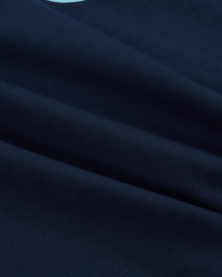 Close-up of dark blue cotton jersey fabric with soft folds and subtle texture, highlighting the smooth surface—evoking the classic Chicago Cats Vintage Collar Soccer Jersey by Ebbets Field.