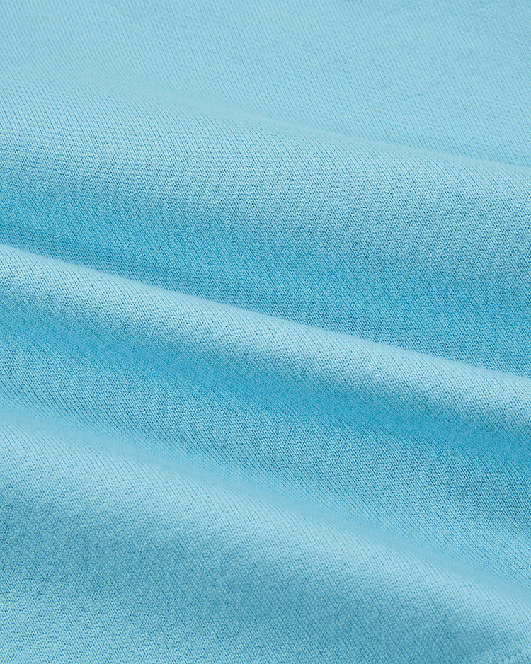 Close-up of light blue Chicago Cats Vintage Soccer Goalie Jersey by Ebbets Field, showing smooth texture, soft folds, and fine weave reminiscent of a classic American Soccer League collared long sleeve design.