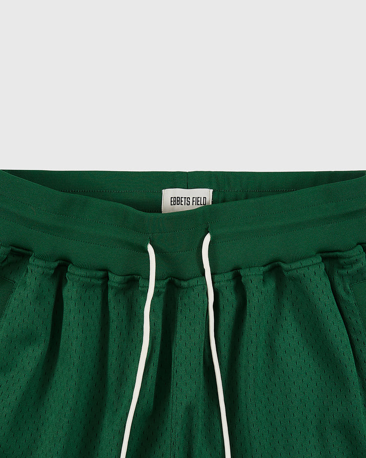 Close-up of the waistband of green New York Cosmos Mesh Soccer Shorts by Ebbets Field, featuring white drawstrings and a sewn-in Ebbets Field label, inspired by Pelé's era.