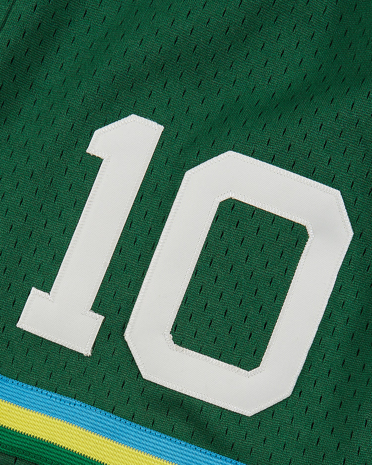 Close-up of green New York Cosmos Mesh Soccer Shorts by Ebbets Field, featuring yellow and blue stripes near the hem and a bold white number 10—a nostalgic tribute to Pelé.