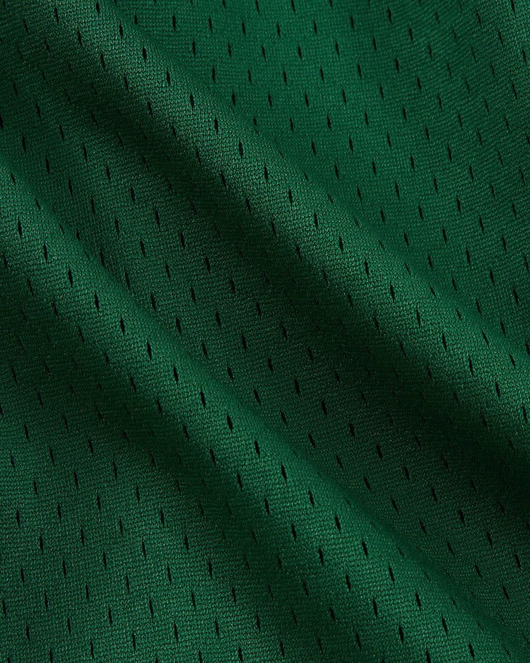 Close-up of the Ebbets Field New York Cosmos Mesh Soccer Shorts fabric, showcasing small, evenly spaced holes and ripples that emphasize its breathable, flexible texture inspired by classic athletic gear.