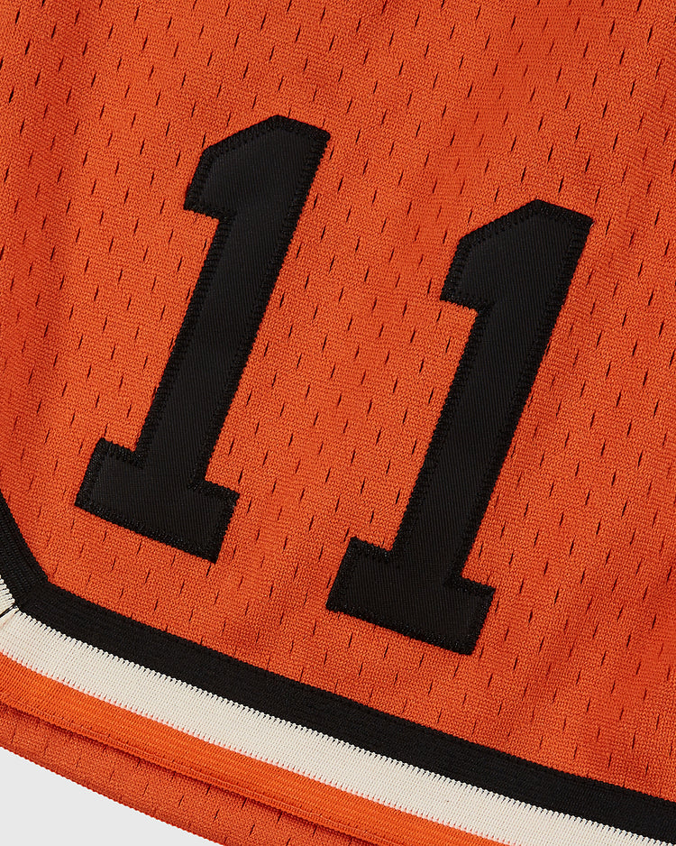 Close-up of Ebbets Field Los Angeles Aztecs mesh soccer shorts in orange, featuring black and white stripes along the hem and mesh fabric—ideal for fans of classic soccer apparel.