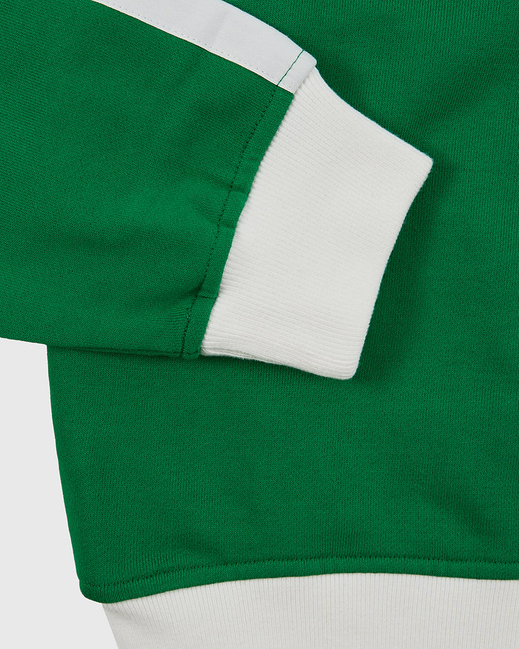 Close-up of the Ebbets Field New York Cosmos Soccer Warm Up Jacket in green, featuring white ribbed cuffs and waistband, a white stripe on the upper sleeve, and soft textured fabric.