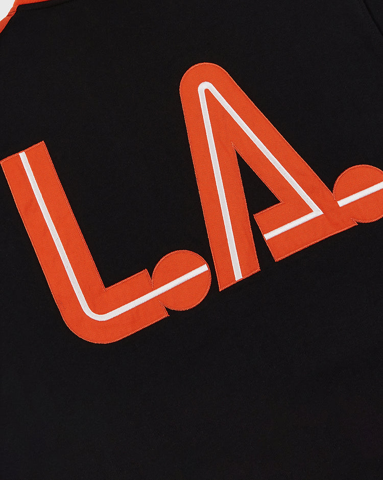 The Ebbets Field Los Angeles Aztecs Soccer Warm Up Jacket is a black zip jacket with bold red and white outlined 