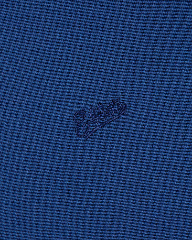Close-up of blue fabric from the Pennsylvania Stoners Soccer Warm Up Jacket, featuring Ebbets Field embroidered in matching blue cursive script.