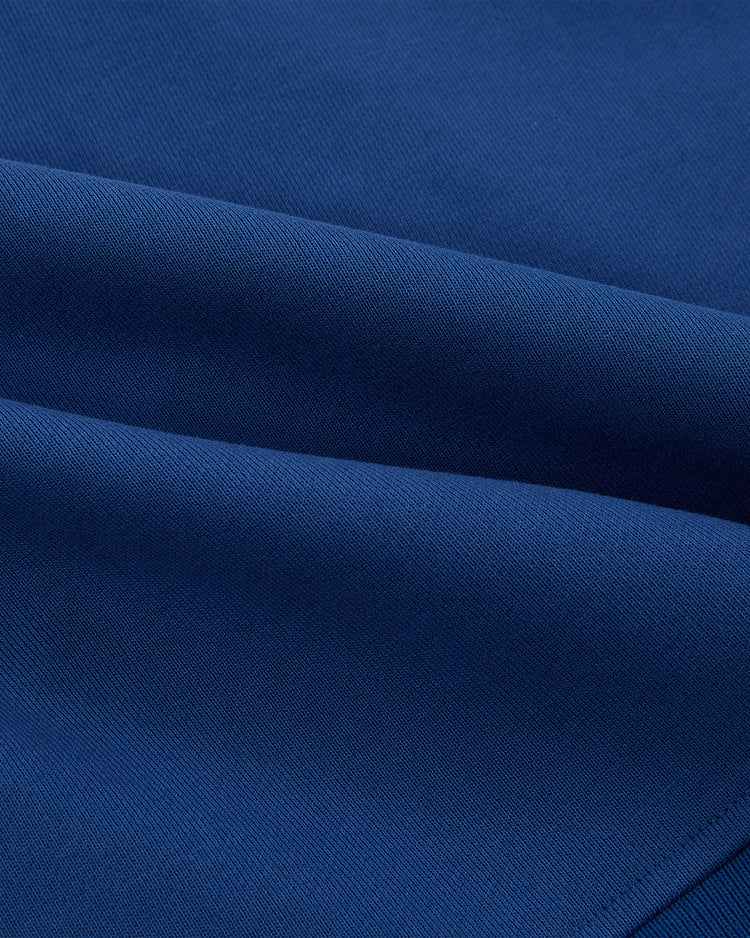 Close-up of smooth, dark blue fabric with visible weave, folded in soft layers—like the classic Pennsylvania Stoners Soccer Warm Up Jacket by Ebbets Field.