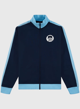The Ebbets Field Chicago Cats Soccer Warm Up Jacket in navy features light blue cuffs, collar, and shoulder stripes, plus a left chest patch of a cartoon cat with glasses. The jacket is displayed flat on a white background.