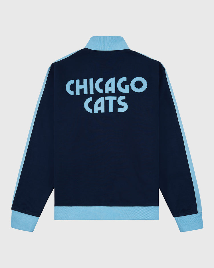 The Ebbets Field Chicago Cats Soccer Warm Up Jacket features a navy blue body, light blue collar, cuffs, side stripes, and bold CHICAGO CATS text on the back—a stylish nod to the American Soccer League.
