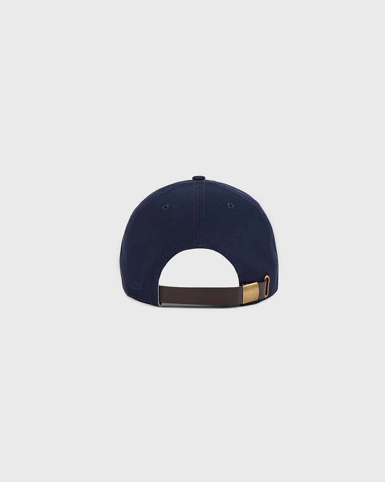The Ebbets Field Boston Minutemen Cotton Twill Ballcap is shown from the back, highlighting its brown adjustable strap with brass buckle against a plain light gray background.