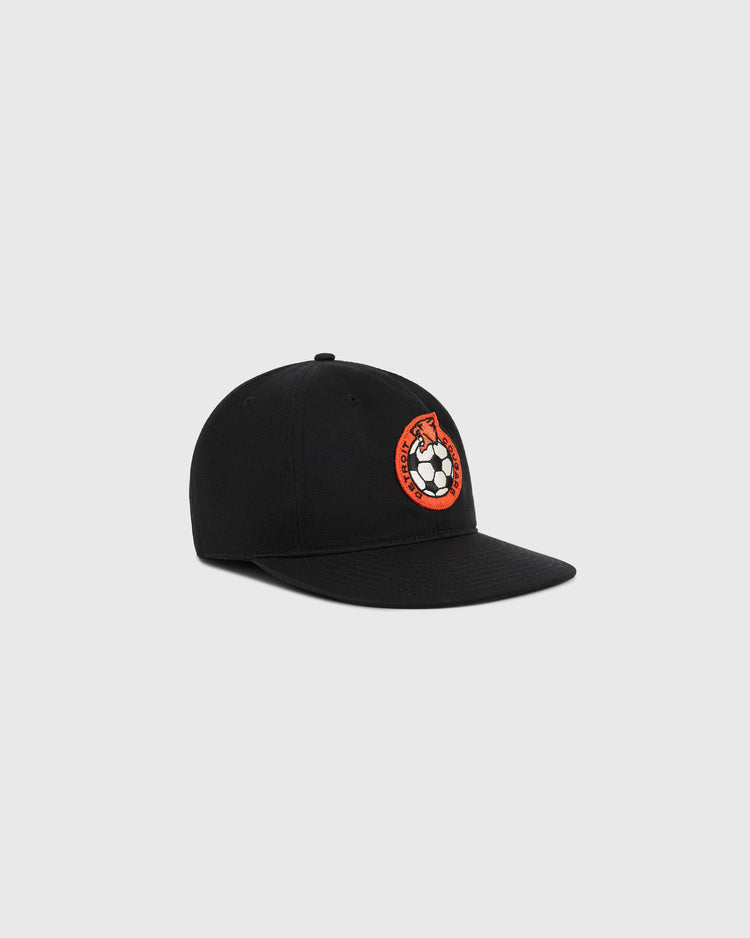 The Ebbets Field Detroit Cougars Cotton Twill Ballcap is a black baseball cap with an embroidered red and white soccer ball logo, inspired by the classic Detroit Cougars design, shown against a plain light gray background.