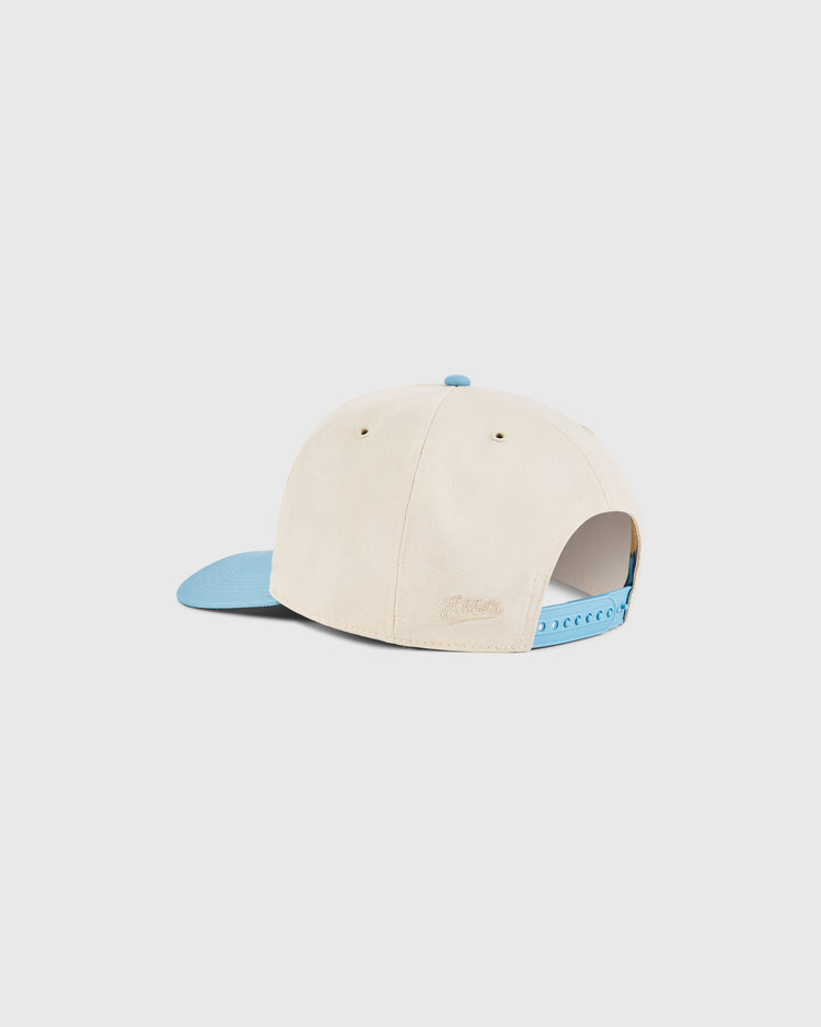 The Dallas Tornados A-Frame Cotton Twill Ballcap by Ebbets Field features a beige retro design, light blue brim, and adjustable light blue snapback, displayed from the back on a white background—ideal for Dallas Tornados fans.