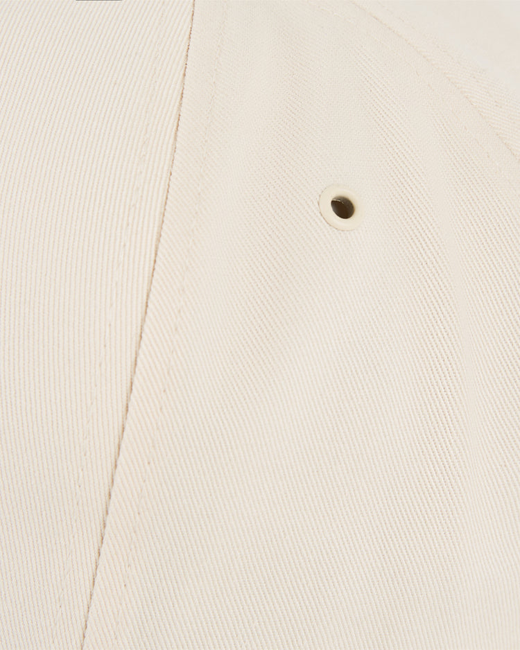 Close-up of the beige cotton twill on the Ebbets Field Dallas Tornados A-Frame Ballcap, highlighting its textured fabric, precise stitching, and a small metal ventilation eyelet.