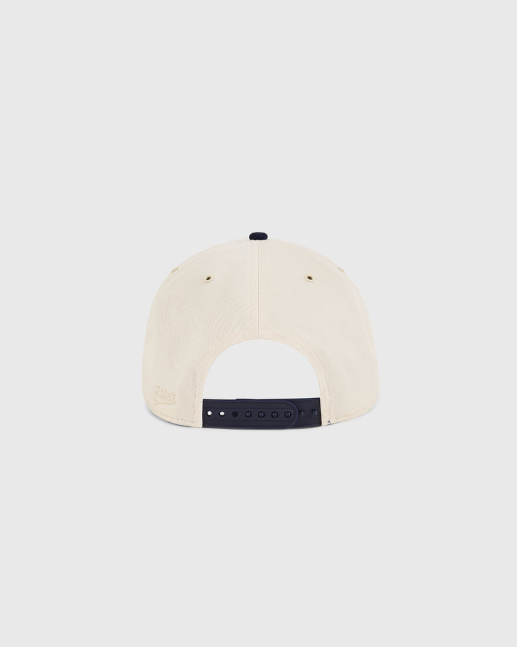 The New Jersey Americans A-Frame Cotton Twill Ballcap by Ebbets Field is a beige retro snapback viewed from the back, featuring a black adjustable strap and two ventilation eyelets on each side.