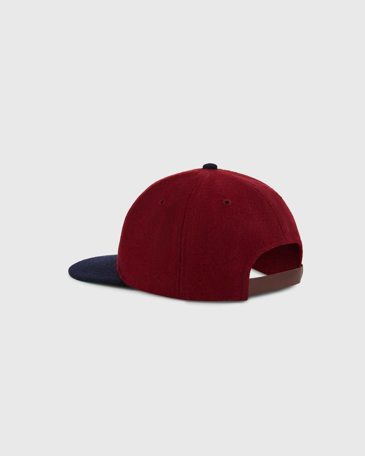 The Ebbets Field Reddy Kilowatt 1940 Wool Ballcap for youth is maroon with a dark blue brim, shown from the back with its adjustable strap, set against a plain light gray background.