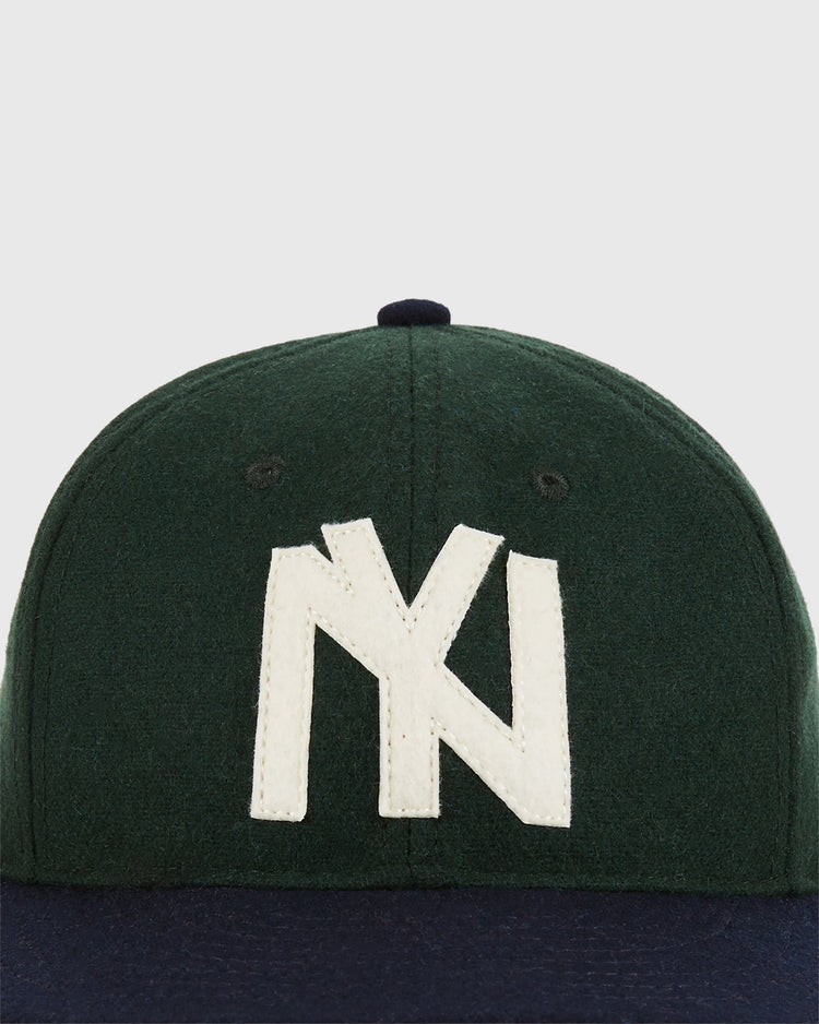 The Ebbets Field Brooklyn Eagles 1935 Wool Ballcap - Youth Size is a dark green cap with a navy blue brim, inspired by classic Negro Leagues hats, and features a large white NY logo stitched on the front.