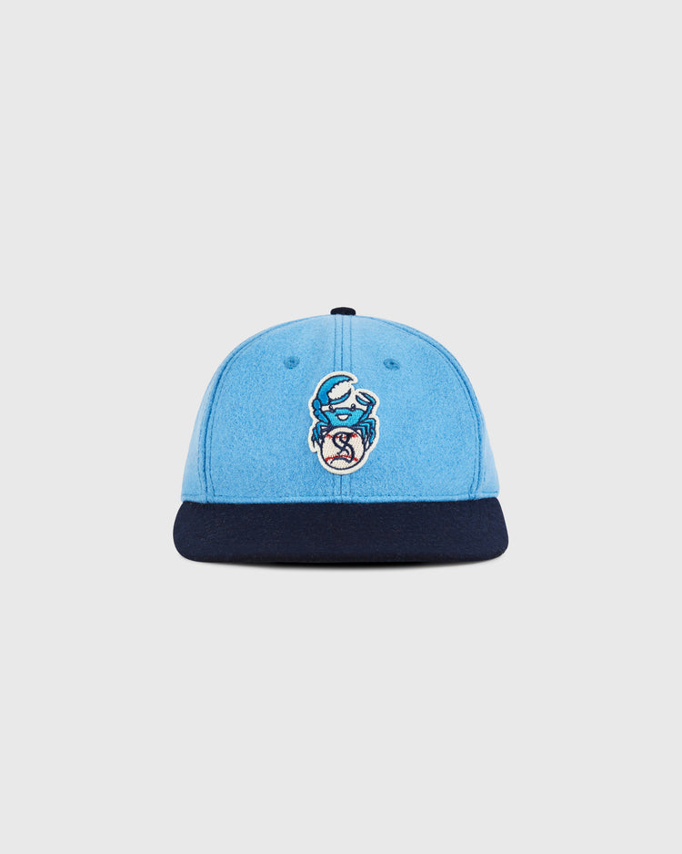 The Ebbets Field Santurce Cangrejeros Crab Wool Ballcap features light blue wool, a navy brim, and an embroidered blue crab with a baseball—honoring Puerto Rican baseball. Shown on a simple light background.