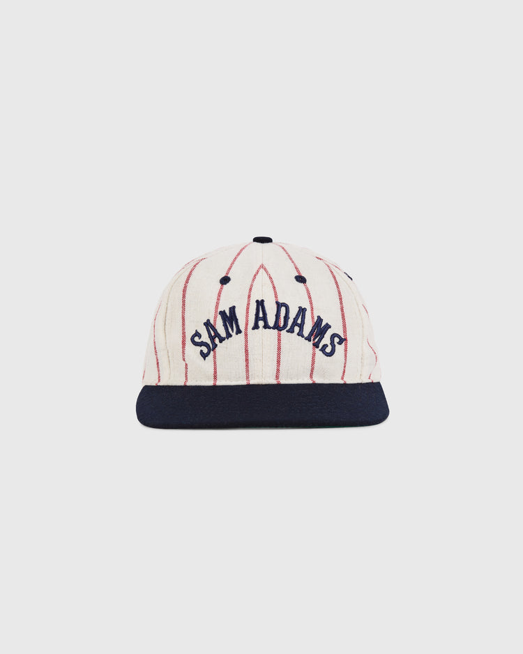 The Ebbets Field Sam Adams Pinstripe Wool Ballcap features cream wool with thin red pinstripes, a navy brim, and 
