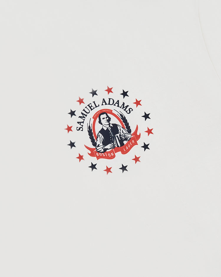 White tee by Ebbets Field featuring a Sam Adams Bottle Cap graphic in the center. This short sleeve shirt is perfect for fans of Boston’s favorite lager.