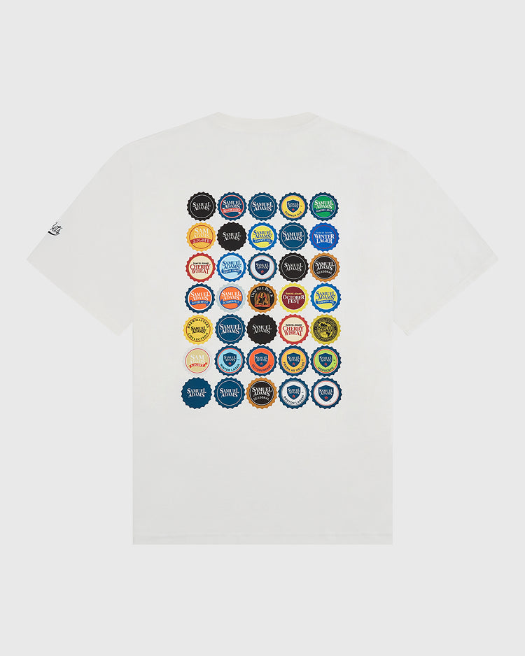 The Sam Adams Bottle Cap Short Sleeve Graphic T-Shirt by Ebbets Field features a grid of 36 colorful, unique bottle caps on the back—each with different logos and text—from their exclusive collaboration collection.