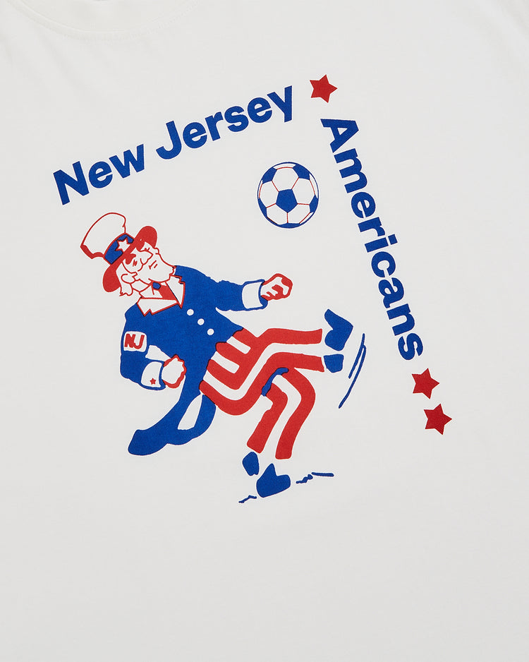 The Ebbets Field New Jersey Americans Short Sleeve Graphic T-Shirt features Uncle Sam kicking a soccer ball with 